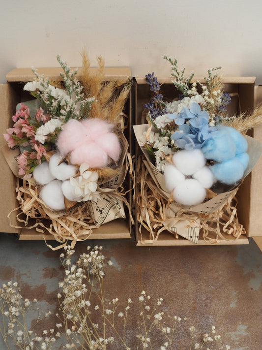 A teeny, ready-to-gift mini bouquet—just perfect for congratulations or a sweet gender reveal moment. Featuring pink or blue cotton snuggled amongst a playful mix of dried florals, each bouquet is wrapped in vintage music sheets for a touch of whimsy. Nestled inside a neutral kraft gift box to keep the colour a secret until the big surprise (Box 15 × 11.2 × 5.6 cm).